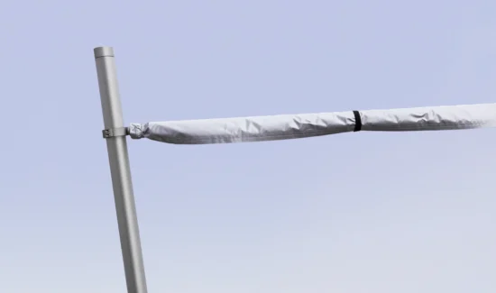 Weißer Sonnenschutz auf einer silbernen Stange vor klarem Himmel