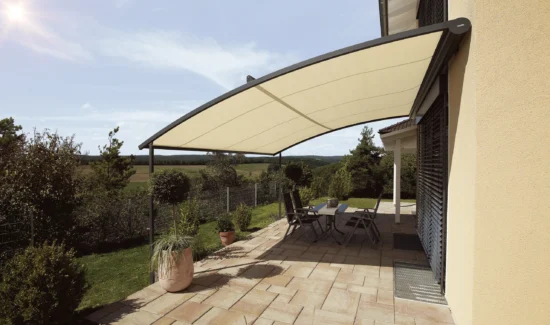 Moderne Terrassenüberdachung mit stilvollen Möbeln bei Sonnenschein